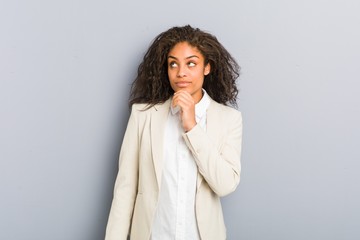 Young african american business woman looking sideways with doubtful and skeptical expression. - obrazy, fototapety, plakaty