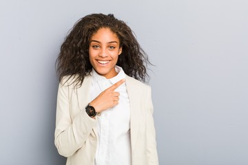 Young african american business woman smiling and pointing aside, showing something at blank space.