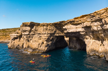 Fototapeta na wymiar Group of kayakers under cave. Comino island. Drone landscape. Europe. Malta island 