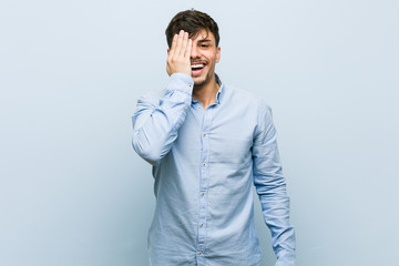 Young hispanic business man having fun covering half of face with palm.