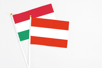 Austria and Hungary stick flags on white background. High quality fabric, miniature national flag. Peaceful global concept.White floor for copy space.