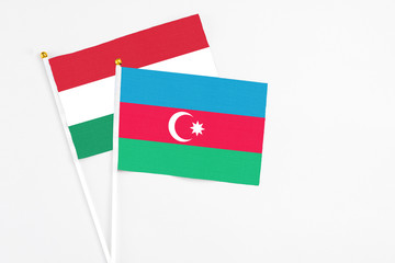 Azerbaijan and Hungary stick flags on white background. High quality fabric, miniature national flag. Peaceful global concept.White floor for copy space.