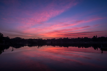 Obraz premium pink clouds at sunrise at park with lake