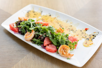 Delicious dish with grilled shrimps, slice grapefruit and arugula salad and spicy fried prawns. Restaurant menu, natural and organic food concept.