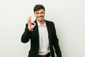 Young business hispanic man cheerful and confident showing ok gesture.