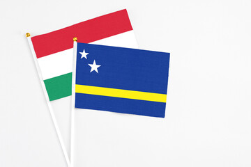 Curacao and Hungary stick flags on white background. High quality fabric, miniature national flag. Peaceful global concept.White floor for copy space.