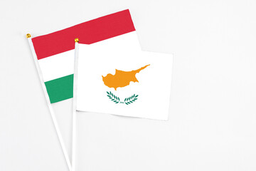 Cyprus and Hungary stick flags on white background. High quality fabric, miniature national flag. Peaceful global concept.White floor for copy space.