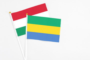 Gabon and Hungary stick flags on white background. High quality fabric, miniature national flag....
