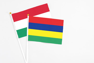 Mauritius and Hungary stick flags on white background. High quality fabric, miniature national flag. Peaceful global concept.White floor for copy space.