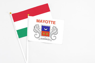 Mayotte and Hungary stick flags on white background. High quality fabric, miniature national flag. Peaceful global concept.White floor for copy space.