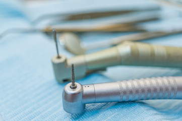 Professional dental tools on a doctor's desk. Handpieces and other tools on a blue background. Soft focus, shallow depth of field.