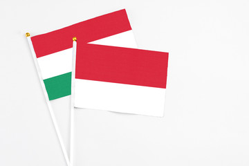 Monaco and Hungary stick flags on white background. High quality fabric, miniature national flag. Peaceful global concept.White floor for copy space.