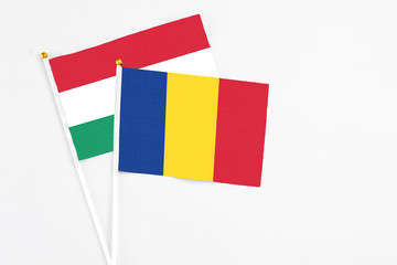 Romania and Hungary stick flags on white background. High quality fabric, miniature national flag. Peaceful global concept.White floor for copy space.