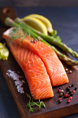 Fresh raw salmon fish fillet, asparagus, lemon, herbs and spices