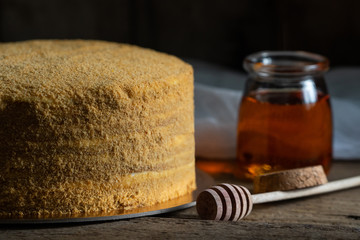honey cake. jar of honey. hand with a spoon for honey. honey drips from a spoon