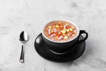 Cup of hot cocoa or hot chocolate with marshmallow in dark cup isolated on bright marble background. Advertising for cafe menu. Coffee shop. Horizontal. traditional drinks for winter time