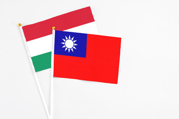 Taiwan and Hungary stick flags on white background. High quality fabric, miniature national flag. Peaceful global concept.White floor for copy space.