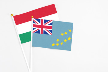 Fototapeta premium Tuvalu and Hungary stick flags on white background. High quality fabric, miniature national flag. Peaceful global concept.White floor for copy space.