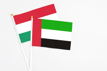 United Arab Emirates and Hungary stick flags on white background. High quality fabric, miniature national flag. Peaceful global concept.White floor for copy space.