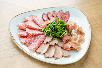 Meat plate, delicacy and Anantipasto. Salami, roast beef, Parma ham, smoked duck breast. Restaurant menu.