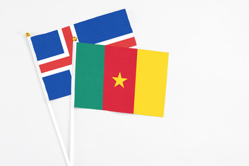 Cameroon and Iceland stick flags on white background. High quality fabric, miniature national flag. Peaceful global concept.White floor for copy space.