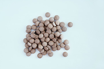 Food supplement. Brown pills on a white background. View from above.