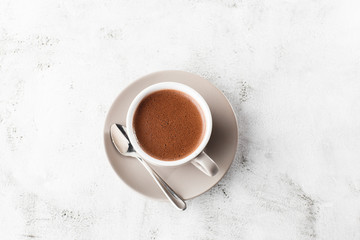 Fototapeta na wymiar Cup of hot cocoa or hot chocolate or americano in white cup isolated on bright marble background. Horizontal photo. traditional drinks for winter time