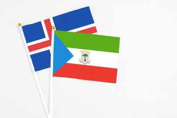 Equatorial Guinea and Iceland stick flags on white background. High quality fabric, miniature national flag. Peaceful global concept.White floor for copy space.