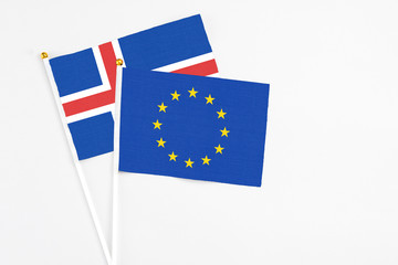 European Union and Iceland stick flags on white background. High quality fabric, miniature national flag. Peaceful global concept.White floor for copy space.