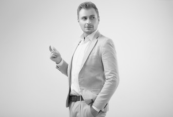 Handsome blonde man model in a fashion gray suit in studio