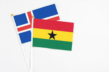 Ghana and Iceland stick flags on white background. High quality fabric, miniature national flag. Peaceful global concept.White floor for copy space.