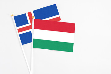 Hungary and Iceland stick flags on white background. High quality fabric, miniature national flag. Peaceful global concept.White floor for copy space.