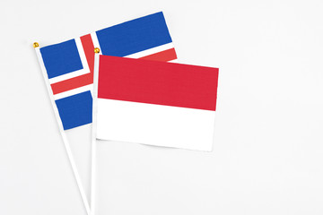 Indonesia and Iceland stick flags on white background. High quality fabric, miniature national flag. Peaceful global concept.White floor for copy space.