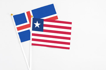 Liberia and Iceland stick flags on white background. High quality fabric, miniature national flag. Peaceful global concept.White floor for copy space.