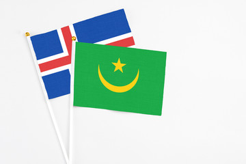 Mauritania and Iceland stick flags on white background. High quality fabric, miniature national flag. Peaceful global concept.White floor for copy space.