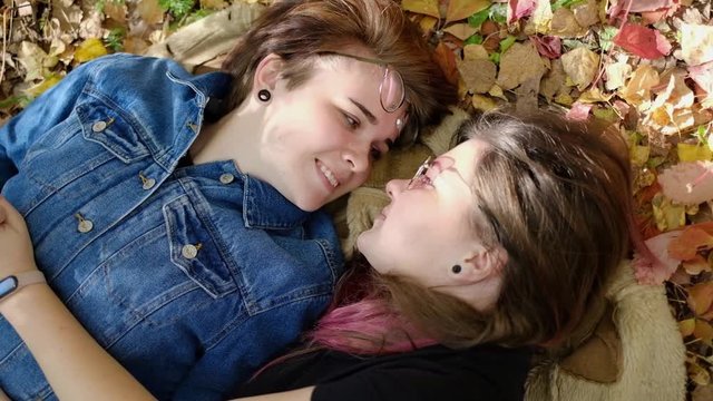 Charming young women kissing gently loving each other stroking touching face skin enjoying romantic tender moments on picnic date in the countryside.