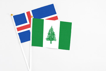 Norfolk Island and Iceland stick flags on white background. High quality fabric, miniature national flag. Peaceful global concept.White floor for copy space.