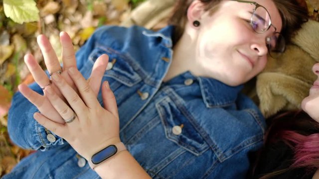 Charming young women kissing gently loving each other stroking touching face skin enjoying romantic tender moments on picnic date in the countryside.
