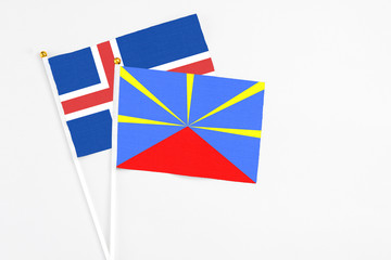 Reunion and Iceland stick flags on white background. High quality fabric, miniature national flag. Peaceful global concept.White floor for copy space.