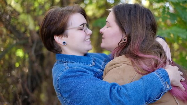 Charming young women kissing gently loving each other stroking touching face skin enjoying romantic tender moments on picnic date in the countryside.