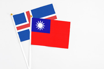 Taiwan and Iceland stick flags on white background. High quality fabric, miniature national flag. Peaceful global concept.White floor for copy space.