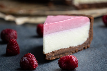 Appetizing slice of cheesecake with pink cream. frozen raspberries