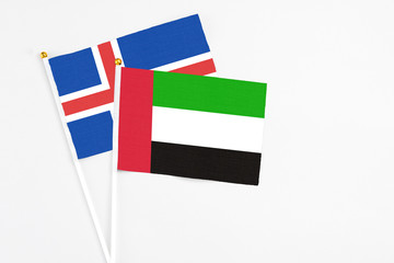 United Arab Emirates and Iceland stick flags on white background. High quality fabric, miniature national flag. Peaceful global concept.White floor for copy space.