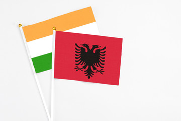 Albania and India stick flags on white background. High quality fabric, miniature national flag. Peaceful global concept.White floor for copy space.