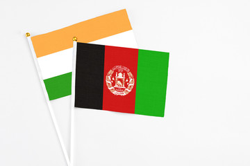 Afghanistan and India stick flags on white background. High quality fabric, miniature national flag. Peaceful global concept.White floor for copy space.