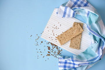 Whole grain cracker on a white wood background. Cereal toasts on a blue background. Healthy eating concept. Place for text