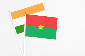 Burkina Faso and India stick flags on white background. High quality fabric, miniature national flag. Peaceful global concept.White floor for copy space.