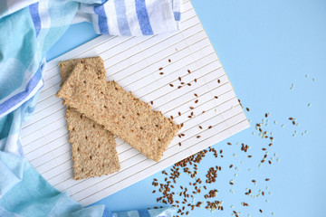 Whole grain cracker on a white wood background. Healthy eating concept