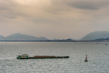 Fototapeta na wymiar Barge with sand pushed at mouth of Long Tau River, Vung Tau city, Vietnam.