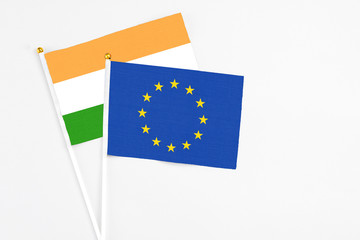 European Union and India stick flags on white background. High quality fabric, miniature national flag. Peaceful global concept.White floor for copy space.